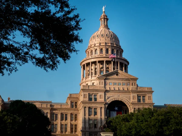 Capital de Texas en Austin con bandera del estado de Texas, árboles en primer plano y cielo azul claro — Foto de Stock