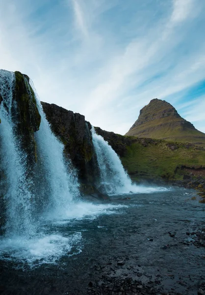 Famous icelandic waterfalls with looming Kirkjufell arrowhead mountain in background — Stock Photo, Image