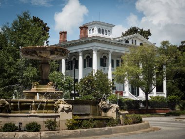 Wilmington Nc 'de güneşli bir günde güzel bir çeşme ve tarihi bir konak.