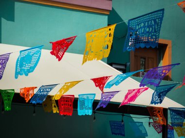 Geleneksel ve renkli Meksika pankartları Ekim festivalinde San Antonio Mercado 'da asılıydı. Güneşli yaz gününde arka planda turkuaz pazar binası. Kimse yok..