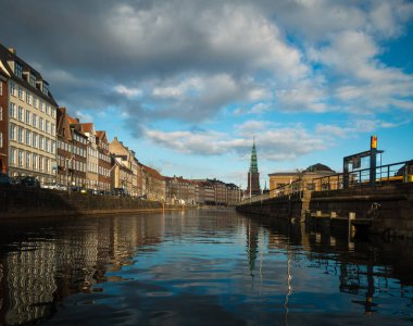 Kopenhag 'ın güzel bir şehri. Kiliseleri ve parçalı bulutlu mavi gökyüzü kanal suyuna yansıyor. İnsan yok, gündüz çekimleri. Şehir manzarası.