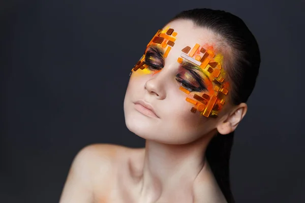 Chica con pedrería naranja y roja en su cara . — Foto de Stock