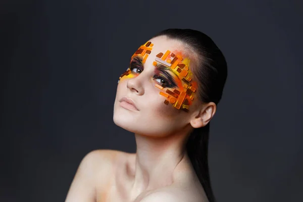 Meisje met sinaasappel en rode steentjes op haar gezicht. — Stockfoto