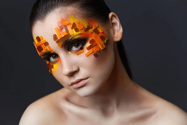 Chica con pedrería naranja y roja en su cara . — Foto de Stock