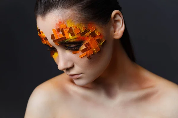 Chica con pedrería naranja y roja en su cara . — Foto de Stock