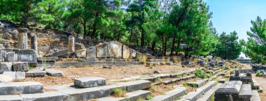 Güneşli bir yaz gününde, Türkiye 'nin Priene kentindeki Batı Kapısı caddesinin kalıntıları.