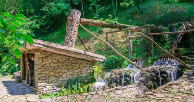Gabrovo, Etar, Bulgaristan - 07.27.2019. Valyavitsa, güneşli bir yaz gününde Bulgaristan 'ın Etar Mimarlık Kompleksi' ndeki fabrikaları dolduruyor. Büyük boyutlu panoramik fotoğraf.