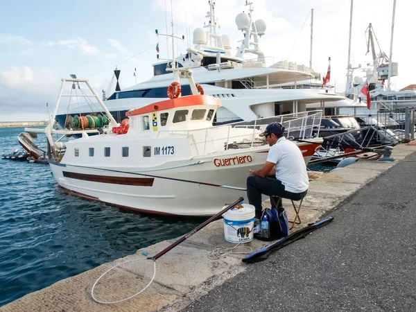 Fisherman sitting at the port — Stock Photo, Image