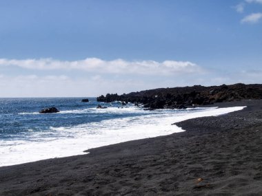 Volkanik kökenli tipik siyah kum plajı.