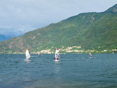 Cremia, İtalya - 5 Eylül 2015: Como Gölü 'nün güneyinden gelen termal rüzgarla çeşitli rüzgar sörfleri ve uçurtmalar.