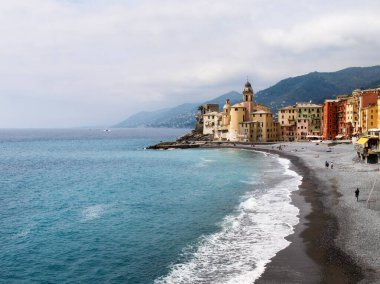 Camogli, İtalya - 11 Nisan 2017: Tipik sahil köyü, marinası ve deniz kenarındaki renkli binalarıyla tanınan turizm merkezi.