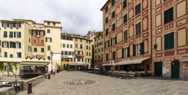 Camogli, İtalya - 11 Nisan 2017: Tipik sahil köyü, marinası ve deniz kenarındaki renkli binalarıyla tanınan turizm merkezi.