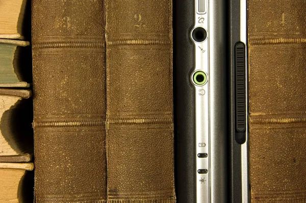 Laptop between old books — Stock Photo, Image