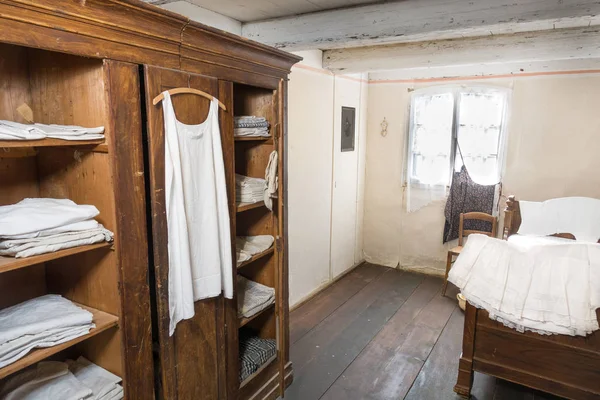 Antiquiertes Schlafzimmer mit Leinenkleidung — Stockfoto