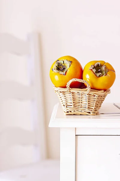 Kaki Fruit Rieten Mand Houten Tafel Stoel Achtergrond — Stockfoto