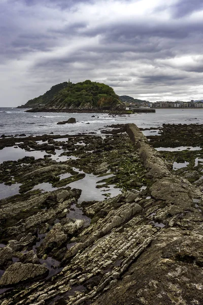 Bask bölgesindeki San Sebastian sahilinde deniz manzarası ve dalgalı kayalıklar.