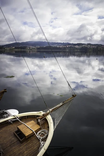 SAILING BOAT MOORED IN THE PORT AND HORIZON OF SKY WITH CLOUDS IN COAST OF THE NORTH OF SPAIN Stock Picture