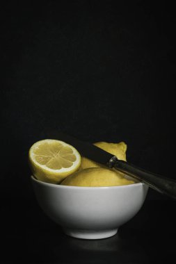 Lemon ve Bıçak Kasesi 'ni Karanlık Arka plan' da kes. Kara Gıda Fotoğrafçılığı