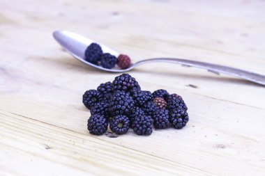 Blackberries N Metal kaşık Tahta Masa üzerinde.