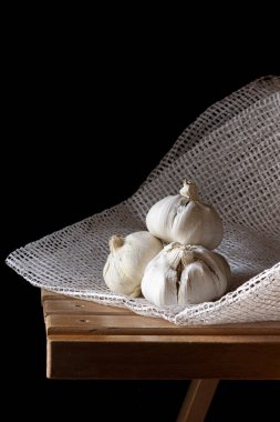 Tahta sandalyede beyaz sarımsak ve karanlık arka plan. Kırsal Gıda Fotoğrafçılığı