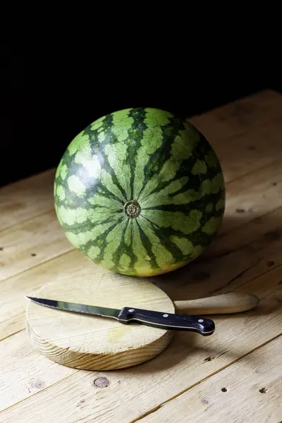 WATERMELON TOGETHER WITH CUTTING BOARD AND KITCHEN KNIFE. RUSTIC FOOD PHOTOGRAPHY — Stock Photo, Image