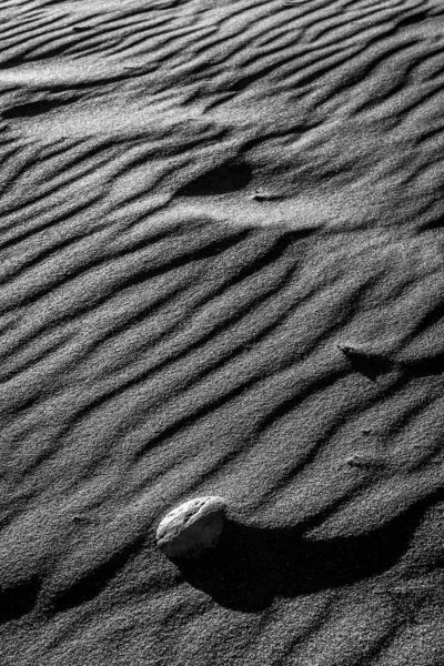Textur und Formen von Sand und weißem Stein am Strand. Schwarz-Weiß-Fotografie — Stockfoto