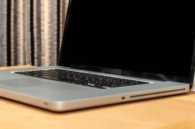 Ofisteki masada siyah ekranlı dizüstü bilgisayar ve kahve fincanı.