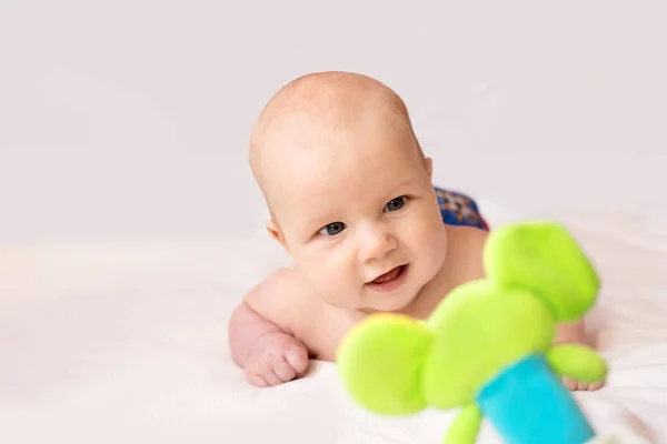 Baby spielt und lächelt mit einem Spielzeug — Stockfoto