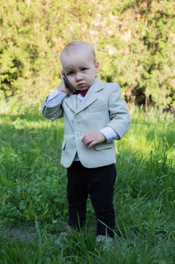 Küçük bir çocuk var konuşma üzerinde cep telefonu açık havada