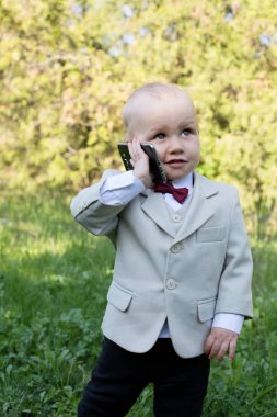 Kırmızı yay ve cep telefonu açık havada küçük mutlu zarif çocukla