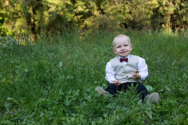Yeşil çim açık havada ve gülümseme oturan mutlu yürümeye başlayan çocuk