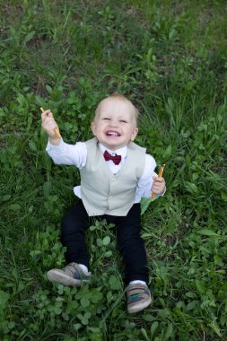 Mutlu gülümseyen bebek çocuk snack açık havada, yeşil çim ile