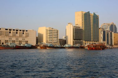 Dubai Creek Körfezi manzarası Deira Binalar ve gün batımında tekneyle