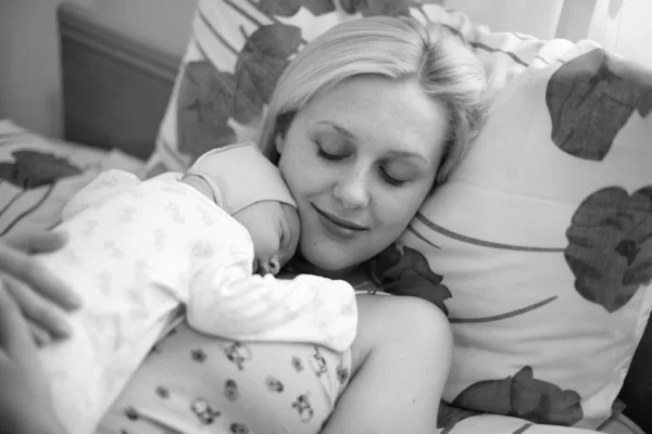 几个小时前分娩后 安详的母亲和新生儿躺在产科医院的枕头上 白黑相间的枪林弹雨 — 图库照片