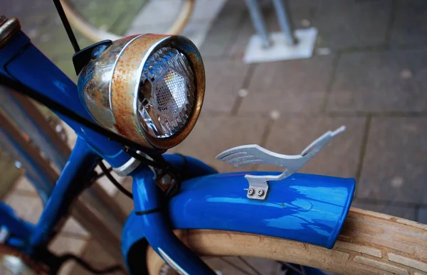 Close up old vintage retro blue bicycle rusty front light, at bike parking in Europe