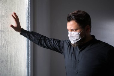 Dünya pandemisi tehdidi. Virüse karşı beyaz tıbbi maske takan adam. Coronavirüs.