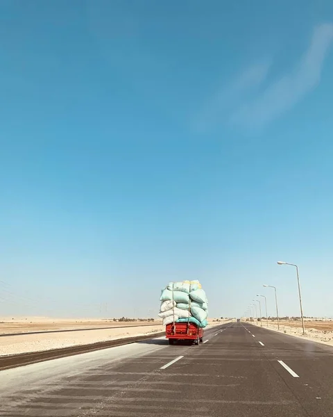 View of road and truck with many sacks, bagged heavy car vehicle body, delivery goods, food far away in Egypt