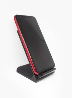 Siyah akıllı telefon istasyonu izole edilmiş beyaz arkaplanda kablosuz hızlı şarj cihazı duruyor