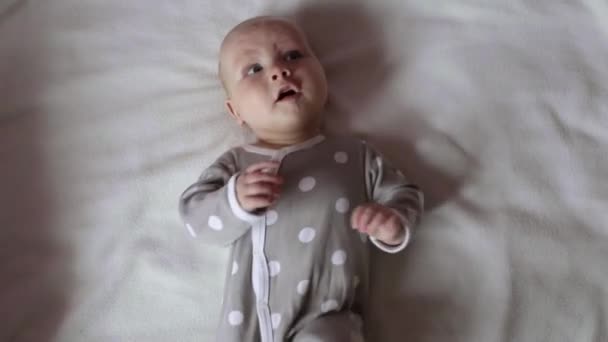 Söt Baby Bär Grå Onesie Overall Med Prickar Ligga Rygg — Stockvideo