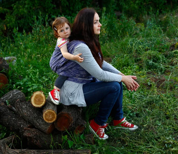 Elegante Mamma Attiva Sedersi Tronchi Legno Sfondo Rurale Indossare Avvolto — Foto Stock