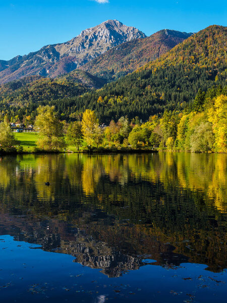 Mountains in autumn colors reflecting Lake Crnava by Preddvor, Slovenia