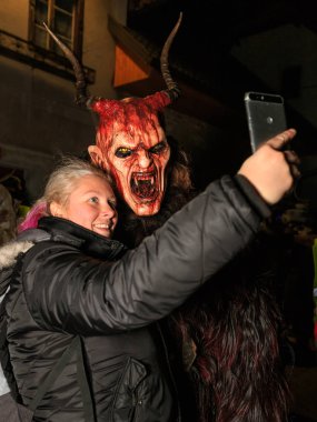 Podkoren, Slovenija - 24 Kasım 2017: kadın bir selfie ile Krampus (şeytan) geleneksel alayı, 