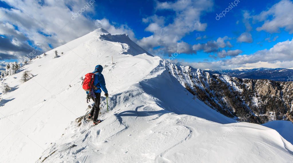 Mountaineer walking on the snowy slope of theDovska Baba mountain in Karavanke range, Slovenia