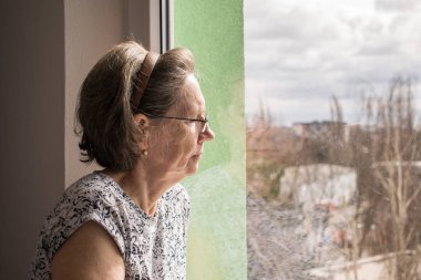  sad lonely old woman look next to  window allone depressed  clipart