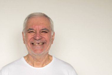 Yaşlı adamın yüzü kapalıyken, diş tebessümü eksikken, düzgün diş bakımı yapılırken.