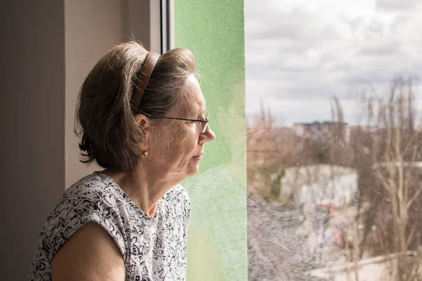 sad lonely old woman look next to  window allone depressed