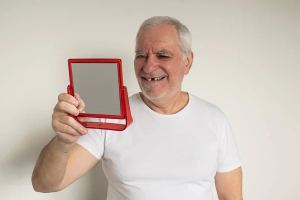 Yaşlı adamın yüzü kapalıyken, diş tebessümü eksikken, düzgün diş bakımı yapılırken.