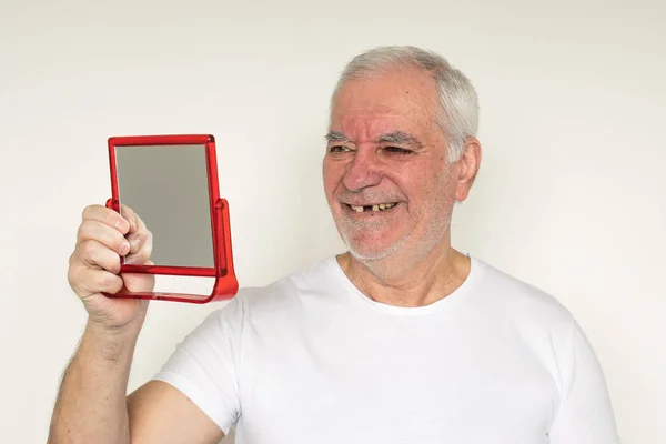 Yaşlı adamın yüzü kapalıyken, diş tebessümü eksikken, düzgün diş bakımı yapılırken.