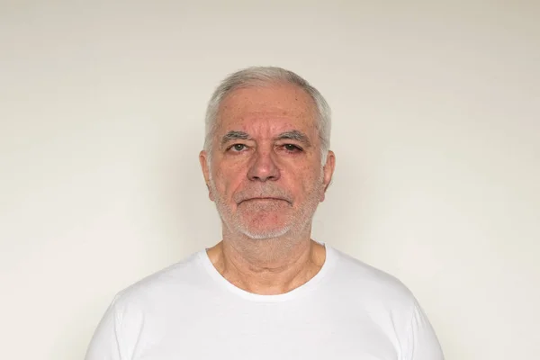 Yaşlı adam kıdemli beyaz t-shirt. Duvarın hemen yanında. Sağlıklı. 