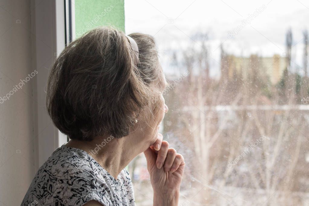  sad lonely old woman look next to  window allone depressed 